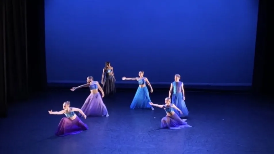 Dancers performing Knock on Wood on a blue-lit stage.