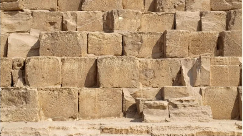 Weathered sandstone blocks stacked in rows.